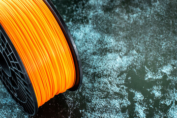 Filament for 3d printing. Bright thermoplastic of neon orange, color. Reel vertical view.