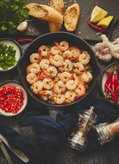 Fried baby Shrimps served on iron pan and fresh herbs and ingredients. Top view, flat lay