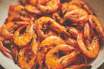 Close up of tasty fried whole prawns with parsley sprigs and garlic. Delicious seafood concept