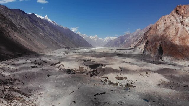 Close aerial view of the Batura glacier morraine with its 57 km length, located near the Hunza valley, surrounded by arid mountains and snowy peaks in the background, Gilgit Baltistan region, Pakistan