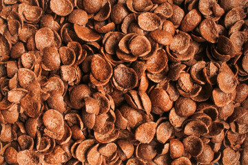 Chocolate cornflakes full frame above. Brown choco cereals backdrop pattern