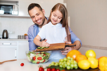 Kid Girl Cooking With Daddy Making Vegetable Salad In Kitchen