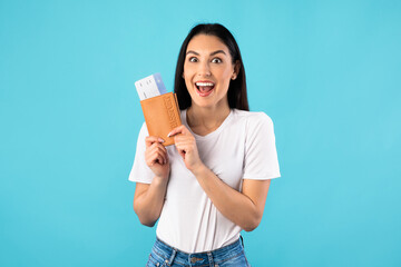 Excited caucasian woman holding tickets and passport