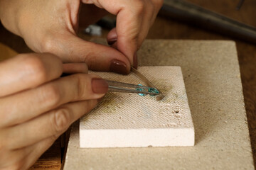 Goldsmiths tools on the jewelry workplace. Tools over rustic wooden background.