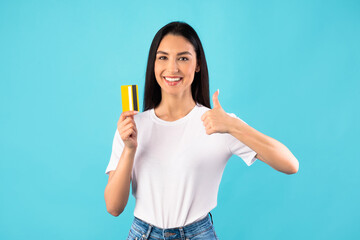 Girl holding credit card and showing thumb up