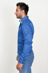 Fototapeta premium Profile view of bearded Indian businessman standing