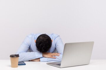 Upset tired man, office employee lying on table, sleeping at workplace, dozing off exhausted bored,...