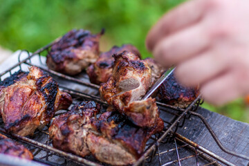 Cooking a barbecue on the fire. Traditional Caucasian kebab on a skewer, cooking meat on skewers. Shish kebab roasting on the grill.