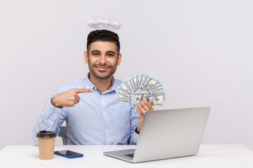 Make money online! Angelic rich businessman with nimbus on head pointing dollar banknotes,...