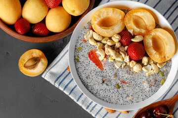 Bowl of chia poudding with pieces of apricots and strawberry