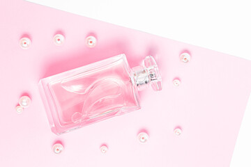 pink perfume bottle with pearls on a pink sheet on a white background copy space. top view, mockup