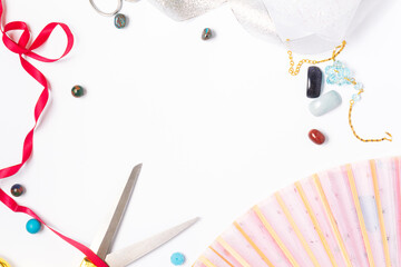 needlework golden scissors ribbons fan natural gems on a light background copy space. top view, frame