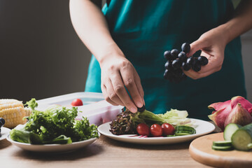 Woman preparing fruit and vegetables for making vegan salad, Healthy food	