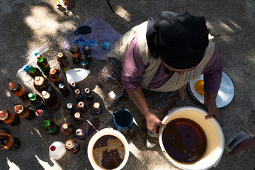 Top view of Turkish woman makes pekmez and bottles them reusing plastic bottles.