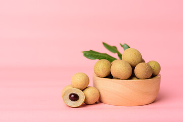 Fresh longan fruit in a bowl on pink background, Tropical fruit