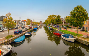 Fototapeta na wymiar Haarlem/Holland - October 06 2019: Boats laying in the water. Canals and historical houses.