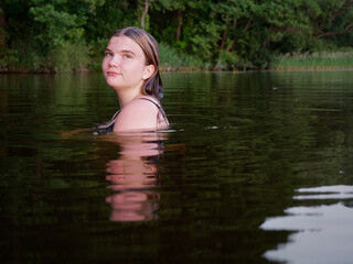 mermaid girl in the water among water lilies at sunset