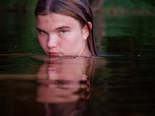 Fototapeta premium mermaid girl in the water among water lilies at sunset