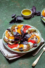 Caprese Tomato and mozzarella slices with basil leaves