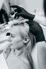 Naklejka premium Young blonde woman with hair loss problem receiving injection, close up
