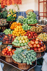 Funchal - Madeira, 20.09.2019. Fruit baskets at a farmers fair. Apples, bananas, peaches, kiwi and others. Vertical photo of a market counter.
