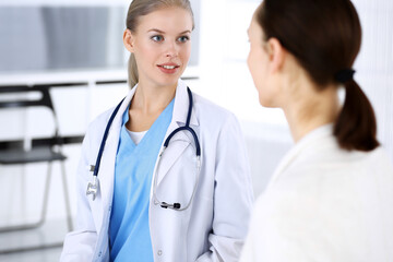 Fototapeta premium Doctor and patient during consultation. Physician at work filling up medication history record while sitting in emergency hospital, portrait shoot. Medicine and health care concept