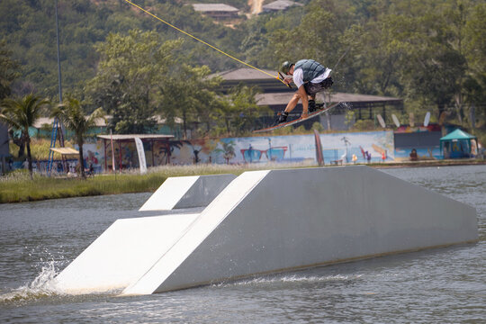 Phuket, Thailand, Cable Way Park, March 17, 2019, A young wakeboarder athlete overcomes an obstacle in the air during a training session.