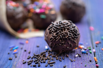 Chocolate donut holes with sprinkles in paper cone, copy space