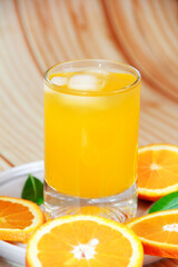 orange drink in a glass and round orange slices