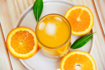 orange drink in a glass and round orange slices