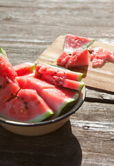 Watermelon slices in the basin on the wooden table