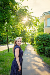 A woman walks in the summer on the streets of the city