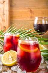 Tinto de Verano or vino de verano, Spanish Wine Cocktail. Refreshment acoholic drink sangria. Cool iced alcohol beverage with lemon juice and slices, wooden background with summer tropical decor copy 