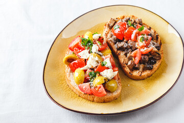 Delicious bruschettas with mushrooms, blue cheese, olives and tomatoes
