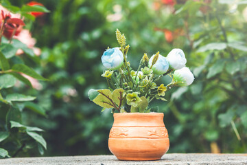 colorful plastic flowers in a pot decorating at a home garden