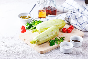 Fresh zucchini on a wooden board with a knife
