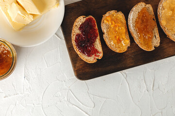 Slice of bread covered with fruit jam on wooden board