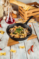 Fried potatoes with beef in cream sauce in a pan