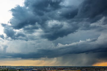 Naklejka na ściany i meble Stormy thunderclouds with heavy rain over the city.