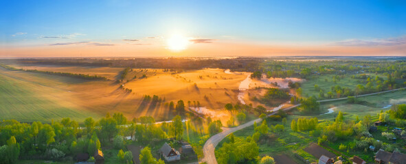 Aerial panoramic view height landscape sun above horizon, forest village with flying birds. Morning fog in the meadows mouth of the river during sunrise countryside.
