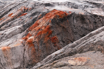 gray weathered desert with ravines and outcrops of red clay minerals