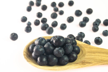 Fresh blueberries on wooden spoon with blurred background