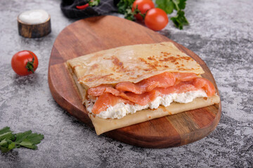 red fish with pancakes on a white plate on a white background