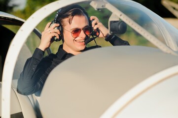 Portrait of confident young man pilot in small plane © Serhii