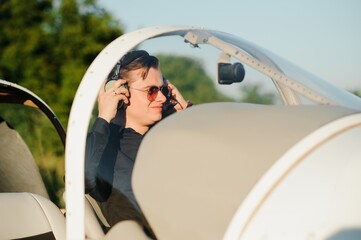 Portrait of confident young man pilot in small plane