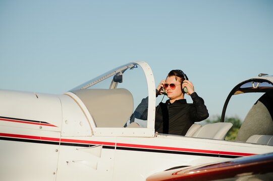 Portrait Of Confident Young Man Pilot In Small Plane