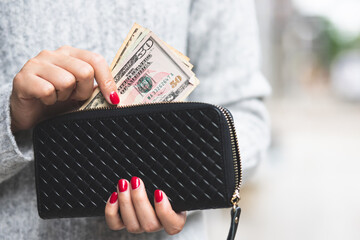 woman person holding a wallet in the hand of a  take money out of pocket. 