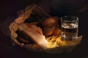 Glass stack with a transparent liquid on a background of crumpled wrapping paper with food, dark...