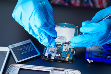 technician repairing inside of hard disk by soldering iron. Integrated Circuit. the concept of...