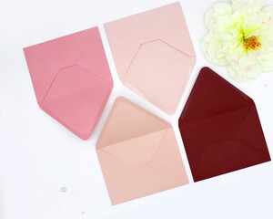 pink colored envelopes on white background. Minimalist styled composition, top view, correspondence...